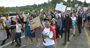 Hundreds of people march from Woodruff Park in west Olympia, Wash., to Olympia City Hall to protest a police shooting that wounded two stepbrothers suspected of trying to steal beer from a grocery store, Thursday, May 21, 2015. (Steve Bloom/The Olympian via AP)