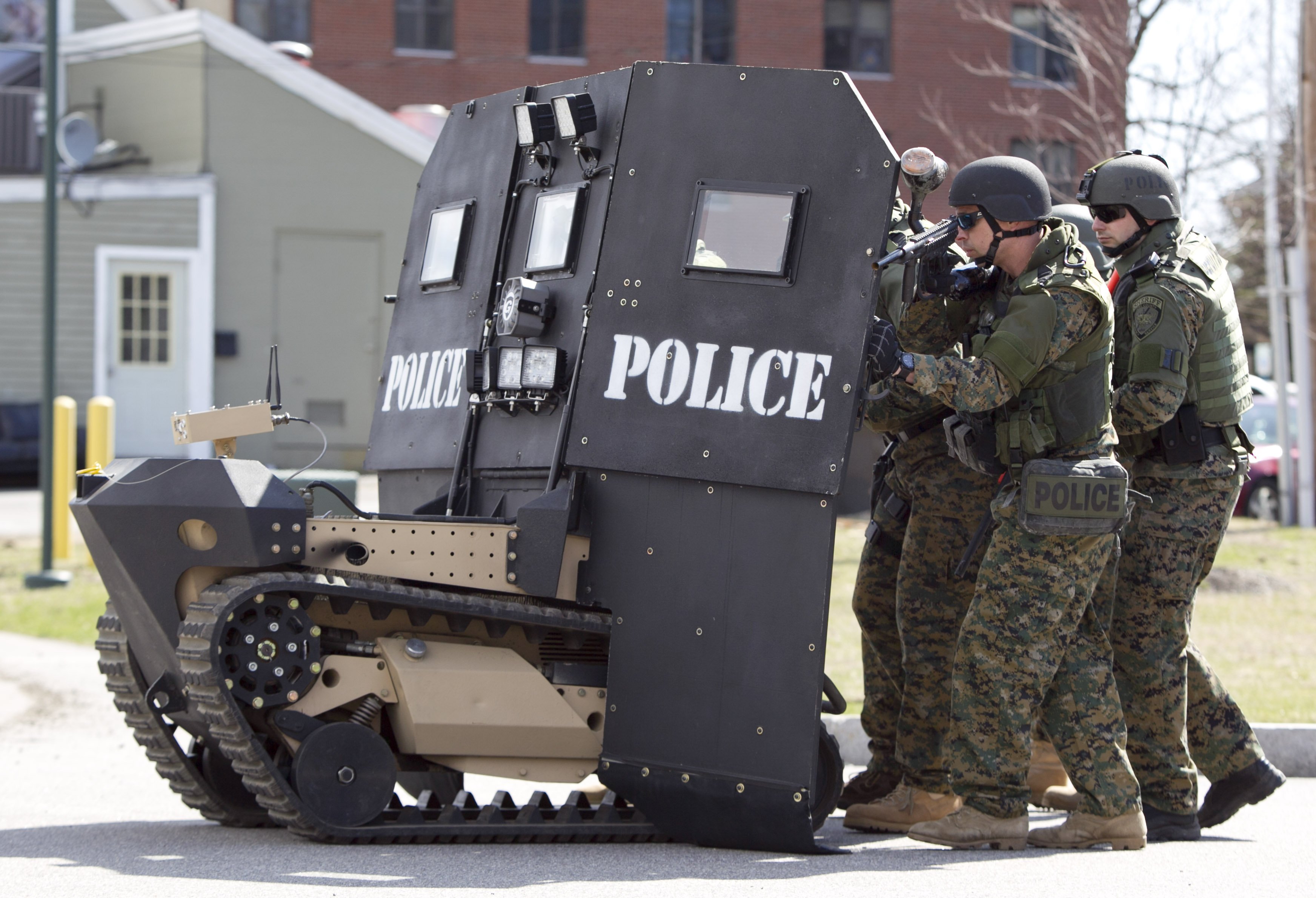 A SWAT robot, a remote-controlled small tank-like vehicle with a shield for officers, is demonstrated for the media in Sanford, Maine on Thursday, April 18, 2013. Howe & Howe Technologies, a Waterboro, Maine company, says their device keeps SWAT teams and other first responders safe in standoffs and while confronting armed suspects. Police now typically use hand-held shields when storming a building. (AP Photo/Robert F. Bukaty)