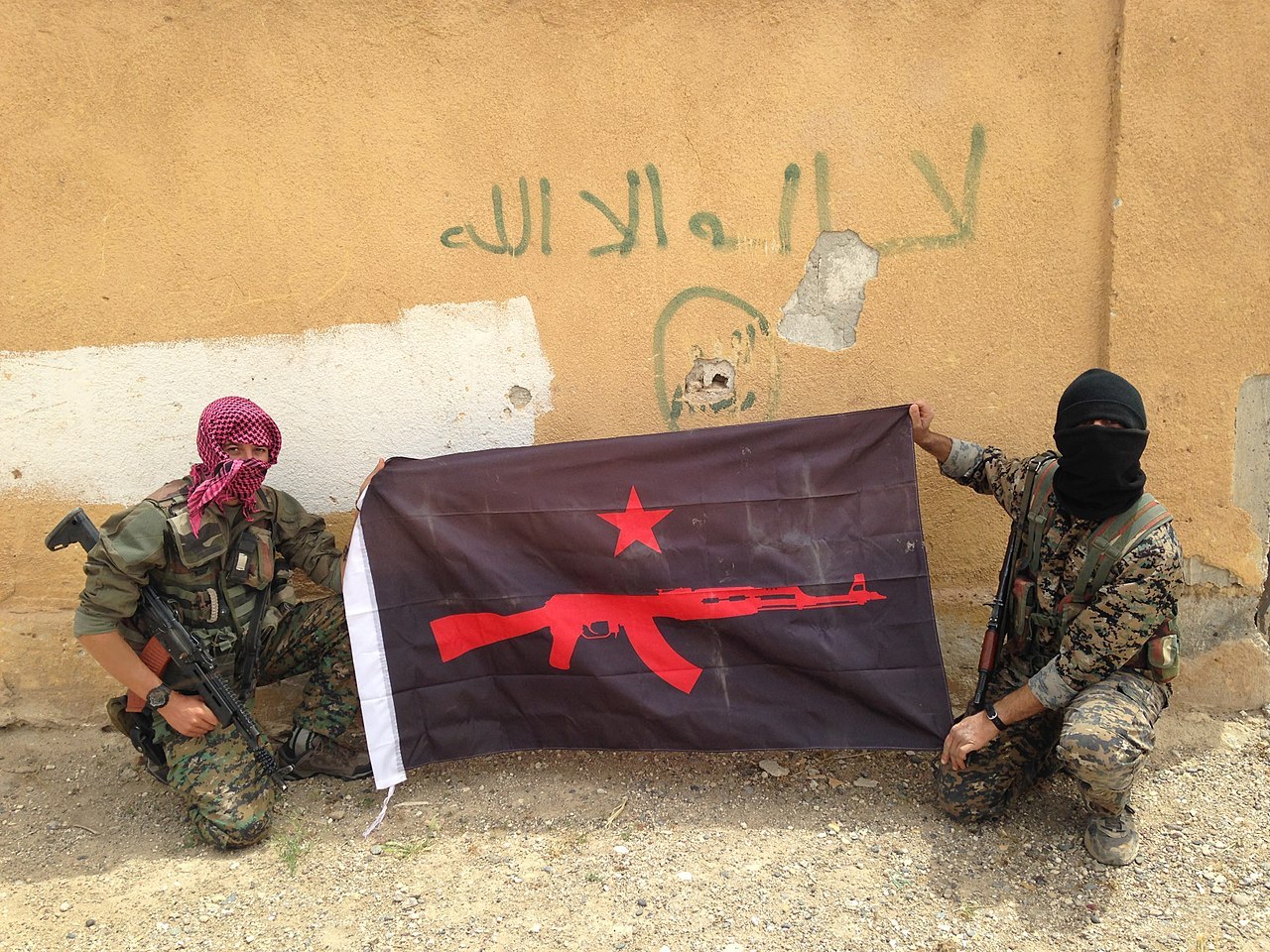 IRPGF fighers holding their flag in Rojava